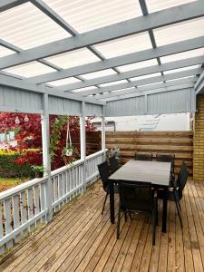 a patio with a table and chairs on a deck at 180m2 Villa with Jacuzzi, Sauna and Garden in Växjö