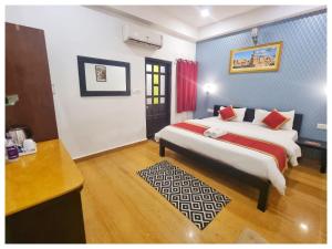 ein Schlafzimmer mit 2 Betten und einem Schreibtisch. in der Unterkunft Hotel Ajanta Haveli in Jaisalmer