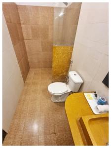 een badkamer met een toilet en een gele wastafel bij Hotel Ajanta Haveli in Jaisalmer