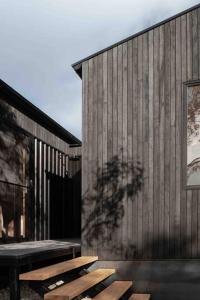 a group of wooden benches next to a building at Common Kosci - luxury bespoke cabin in the Snowies in Jindabyne