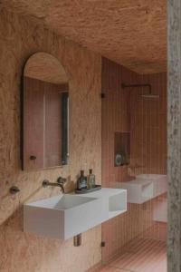 a bathroom with a white sink and a mirror at Common Kosci - luxury bespoke cabin in the Snowies in Jindabyne