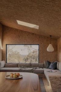 a living room with a couch and a table at Common Kosci - luxury bespoke cabin in the Snowies in Jindabyne