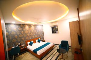 1 dormitorio con 1 cama y sillas en una habitación en ROYAL PALACE, en Bhiwāni