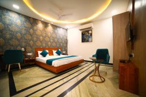 1 dormitorio con 1 cama, 2 sillas y TV en ROYAL PALACE, en Bhiwāni