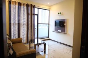 een woonkamer met een bank en een televisie bij HOTEL AKSHAYAM GRAND INN in Yelagiri
