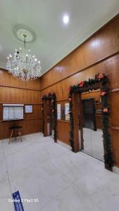 MNK Condo Transient - Albergo Residences في باغيو: غرفة كبيرة بها ثريا وأبواب مع ديكورات عيد الميلاد