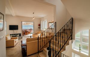 a living room with a staircase with a couch and a tv at Holiday Home Amanda Hollick in Kotor