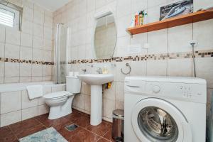 a bathroom with a toilet sink and a washing machine at Holiday Home Amanda Hollick in Kotor