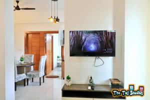 sala de estar con TV de pantalla plana en la pared en The Taj Studios-2Bhk Flat in North Eye Stay with Friend & Family en Noida
