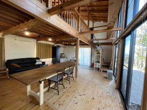 een woonkamer met een grote houten tafel in een loft bij Vineyard Vista Yamanashi in Enzan