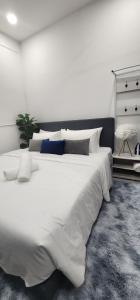 吉隆坡的住宿－Neu Suites @ 3rdNvenue by Perfect Host，白色卧室配有一张带枕头的大白色床