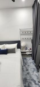 吉隆坡的住宿－Neu Suites @ 3rdNvenue by Perfect Host，卧室配有白色的床和梳妆台。