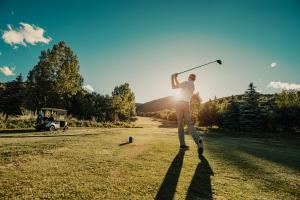 un hombre está jugando golf con un club en Homestead Resort, en Midway