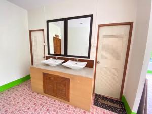a bathroom with two sinks and a large mirror at Lotus Hostel Beach Koh Tao in Ko Tao