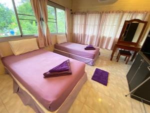 two beds in a room with a tv at Lotus Hostel Beach Koh Tao in Ko Tao
