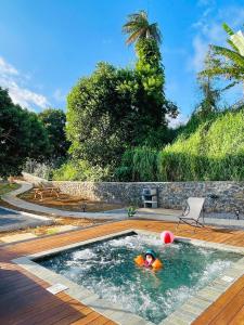 una persona en una piscina con una pelota en el agua en Austral House-chalet sud sauvage, en Saint-Joseph