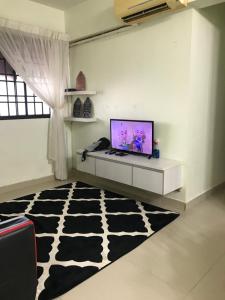 a living room with a television and a cow rug at 9293 Puncak Nearby Bukit Bendera in George Town