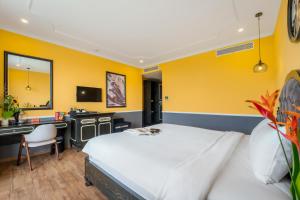 a bedroom with a bed and a desk and a mirror at Athenia Hoi An Boutique Hotel & Spa in Hoi An