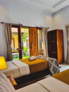 a bedroom with two beds and a window at Hokita Home Stay in Nusa Lembongan