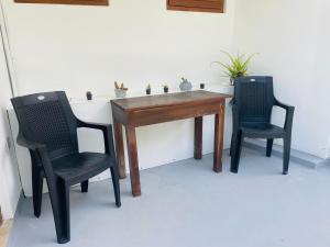 two chairs and a wooden table with two chairs at White House Hotel Mirissa in Mirissa