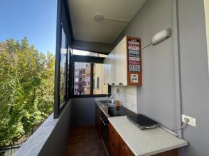 una pequeña cocina con fregadero y ventana en Vivo Apartment en Durrës