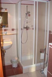 La salle de bains est pourvue d'une douche, de toilettes et d'un lavabo. dans l'établissement Bundi Vendégház, à Kehidakustány