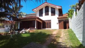 a house with a palm tree in front of it at Absolute Breeze by cherins in Matara