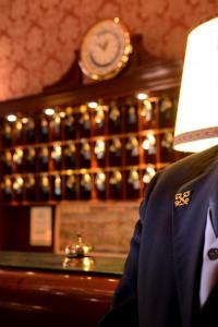 a man in a suit and a clock in a bar at Duodo Palace in Venice