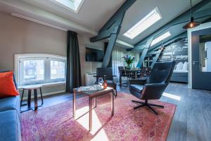 een woonkamer met een bank, een stoel en een tafel bij YAYS Amsterdam Maritime by Numa in Amsterdam