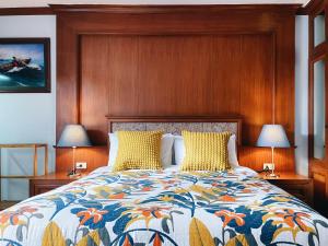 a bedroom with a bed with a wooden headboard and two lamps at Pannarai's House in Bangkok