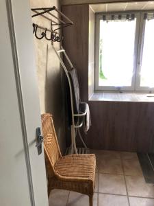 uma cadeira de vime numa casa de banho com uma janela em La Fauconnerie em Bourgneuf-en-Retz