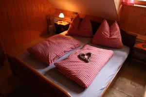 a bed with red and white checkered pillows at Straniger Alm in Stranig