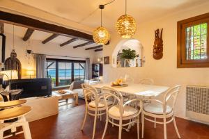 a kitchen and dining room with a table and chairs at Senrramada in Playa Migjorn