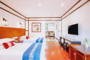 a hotel room with two beds and a flat screen tv at Wenjun Courtyard Hotel ---5 mins walk from Tonghuimen metro station, near Tianfu square, close by culture park and Sichuan opera house, English speaking service, local tours in Chengdu