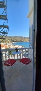 a balcony with two chairs and a table and the ocean at GEORGE HOME in Andros