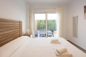 a bedroom with a bed with two towels on it at Zahara Pueblo villas y apartamentos in Zahara de los Atunes