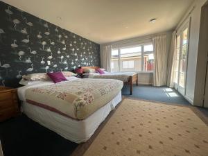 1 dormitorio con 2 camas y una pared con pájaros en Sunny House with 5 Bedrooms(near airport) en Christchurch