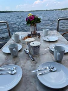 una mesa con platos blancos y utensilios sobre el agua en Hausboot Jette, en Werder