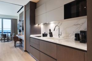 a kitchen with a sink and a living room at JW Marriott Hotel Istanbul Marmara Sea in Istanbul