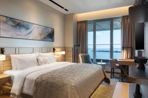 a bedroom with a bed and a desk with a computer at JW Marriott Hotel Istanbul Marmara Sea in Istanbul