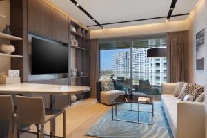 a living room with a tv and a table at JW Marriott Hotel Istanbul Marmara Sea in Istanbul