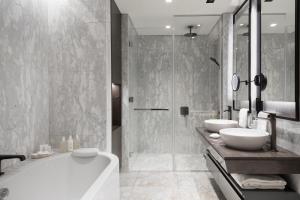 a bathroom with two sinks and a tub and a shower at JW Marriott Hotel Istanbul Marmara Sea in Istanbul