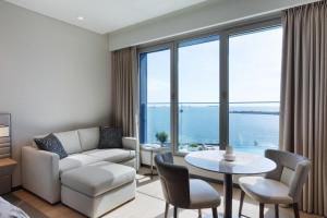 a living room with a couch and a table with chairs at JW Marriott Hotel Istanbul Marmara Sea in Istanbul
