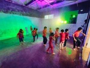 a group of children playing in a room with colored powder at Nisarga Resort in Kaglipur