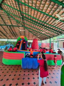eine Gruppe von Kindern, die auf einem Spielplatz im Innenbereich spielen in der Unterkunft Nisarga Resort in Kaglipur