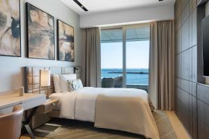 a bedroom with a bed and a desk and a window at JW Marriott Hotel Istanbul Marmara Sea in Istanbul