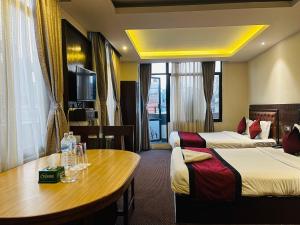 una camera d'albergo con due letti e un tavolo di Hotel de Universal a Kathmandu