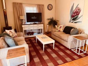 a living room with two couches and a tv at Haze Inn Cottage in Rosetta