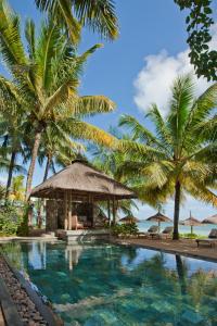 uma piscina com palmeiras e um resort em Heritage Awali Golf & Spa Resort - All Inclusive em Bel Ombre