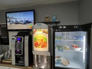 a kitchen with two refrigerators and a tv at Kyriad Direct Val de Reuil in Val de Reuil